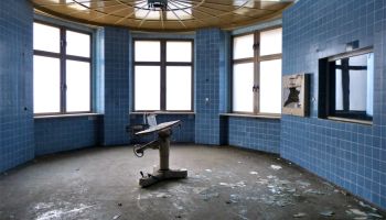 Runder, verlassener Raum mit blauen Fliesen.