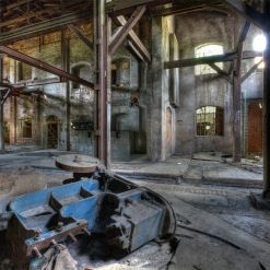 Alte Fabrikhalle mit Rost, Holz und zerfallenden Wauern.